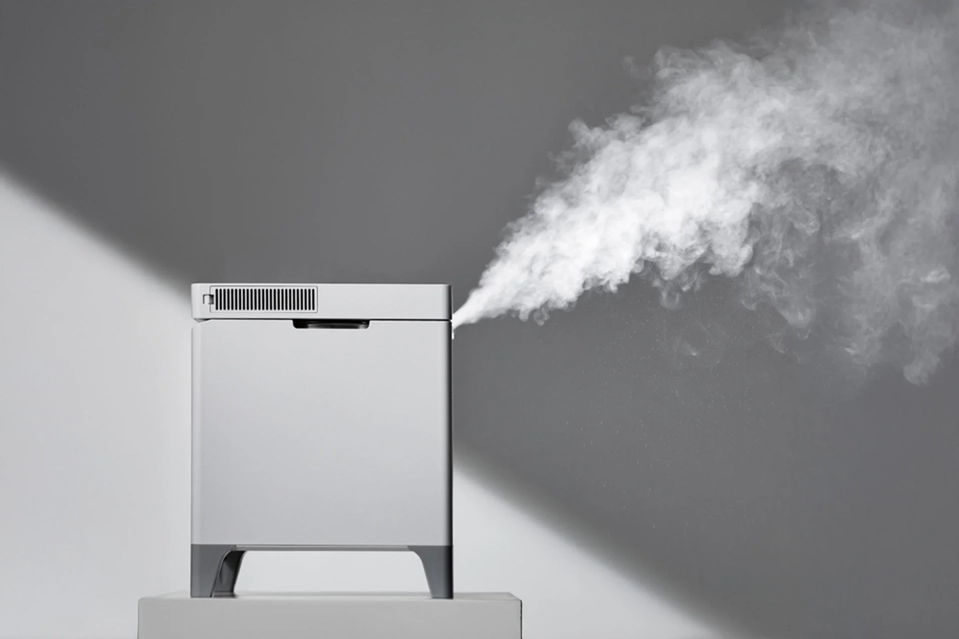 グレーのモダンなデザインの家電製品が白い蒸気を勢いよく噴出している様子