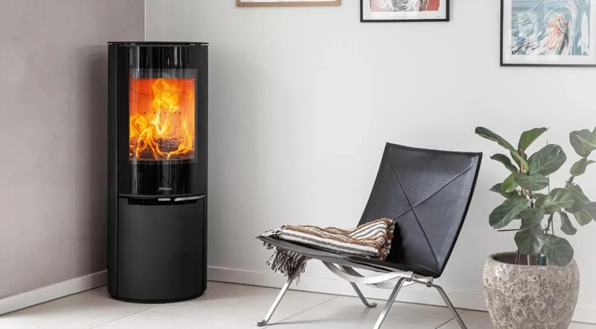 炎が燃えるモダンな黒い薪ストーブが置かれたリビングルームの様子です