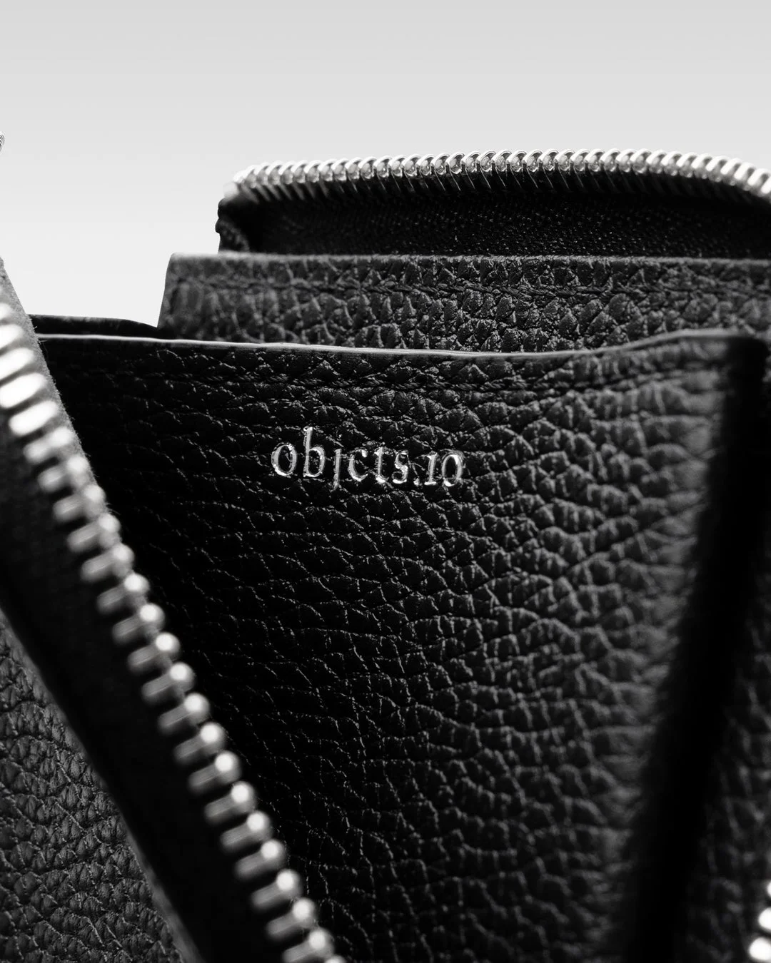 黒い革製財布のジッパーとロゴ