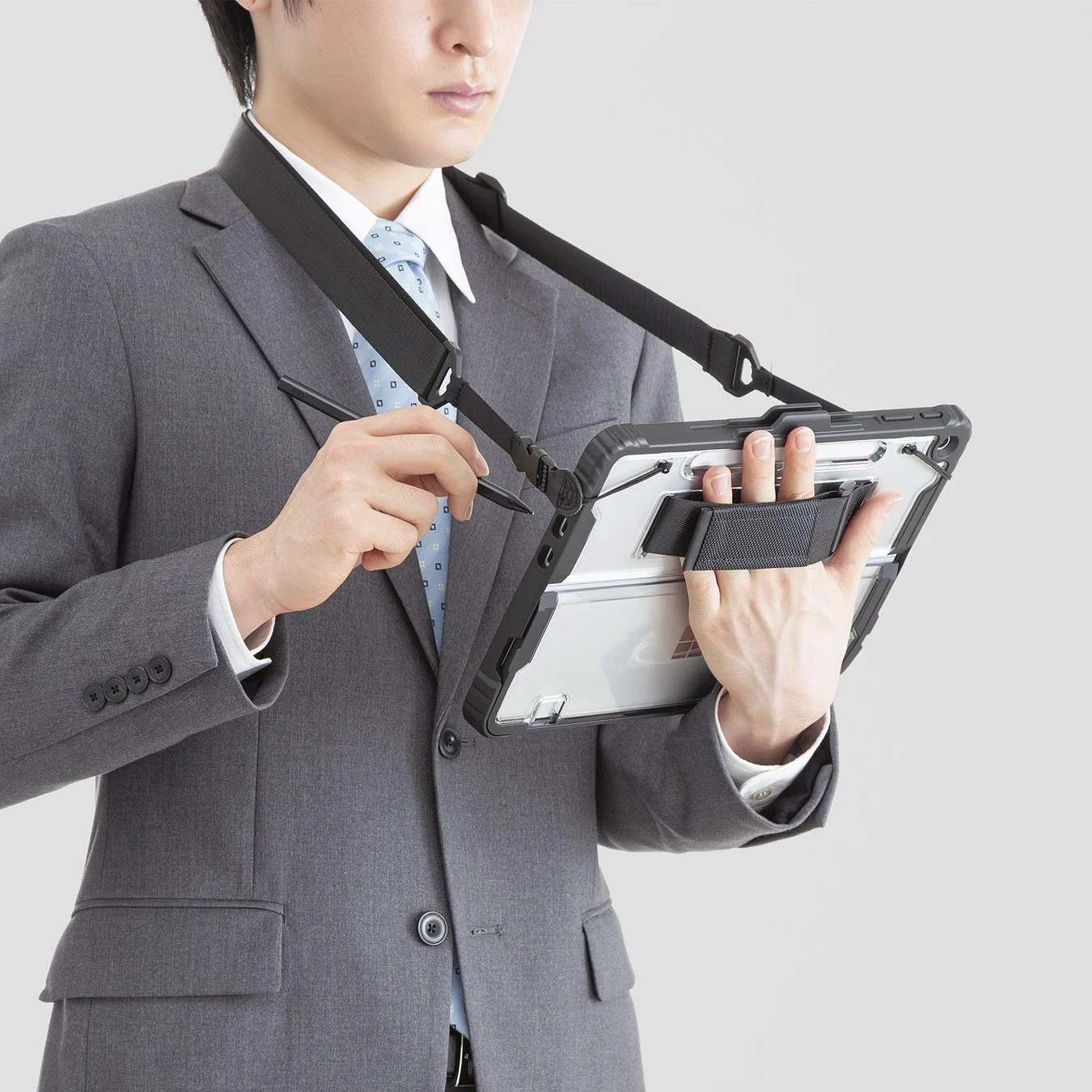 ショルダーベルトでタブレットを操作するビジネスマン