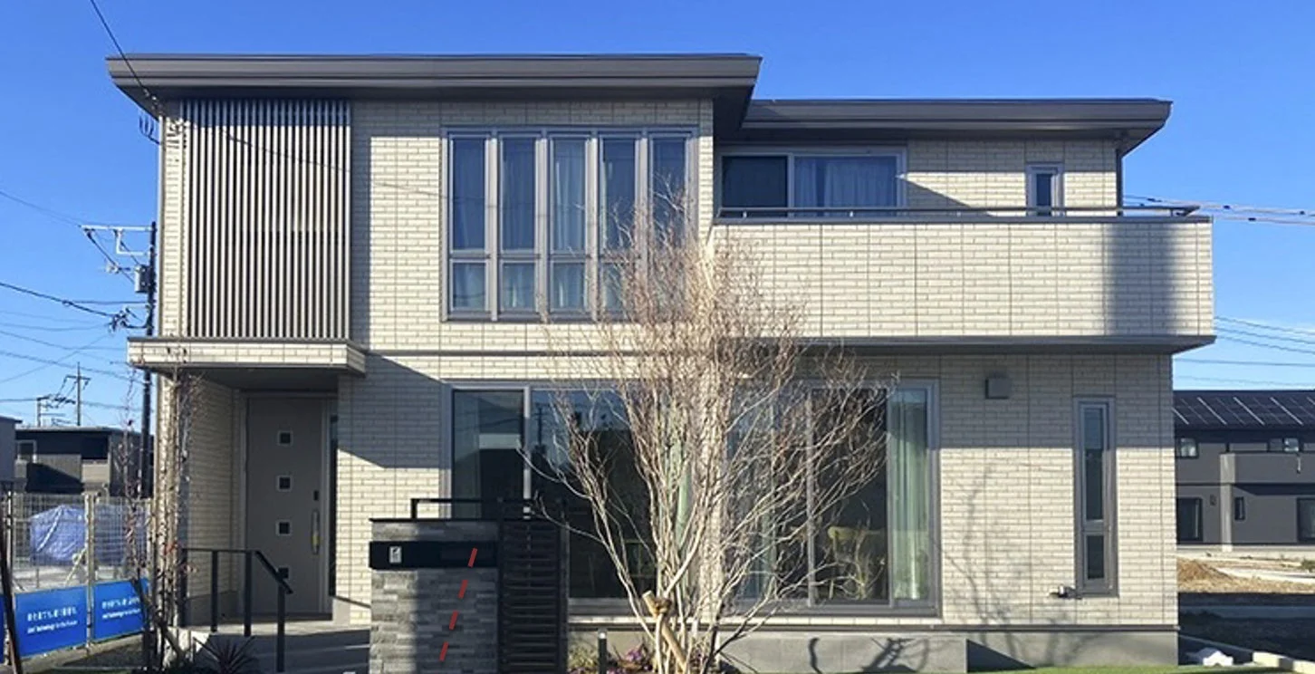 明るいレンガ調の外壁が特徴的な現代的な二階建て一戸建て住宅