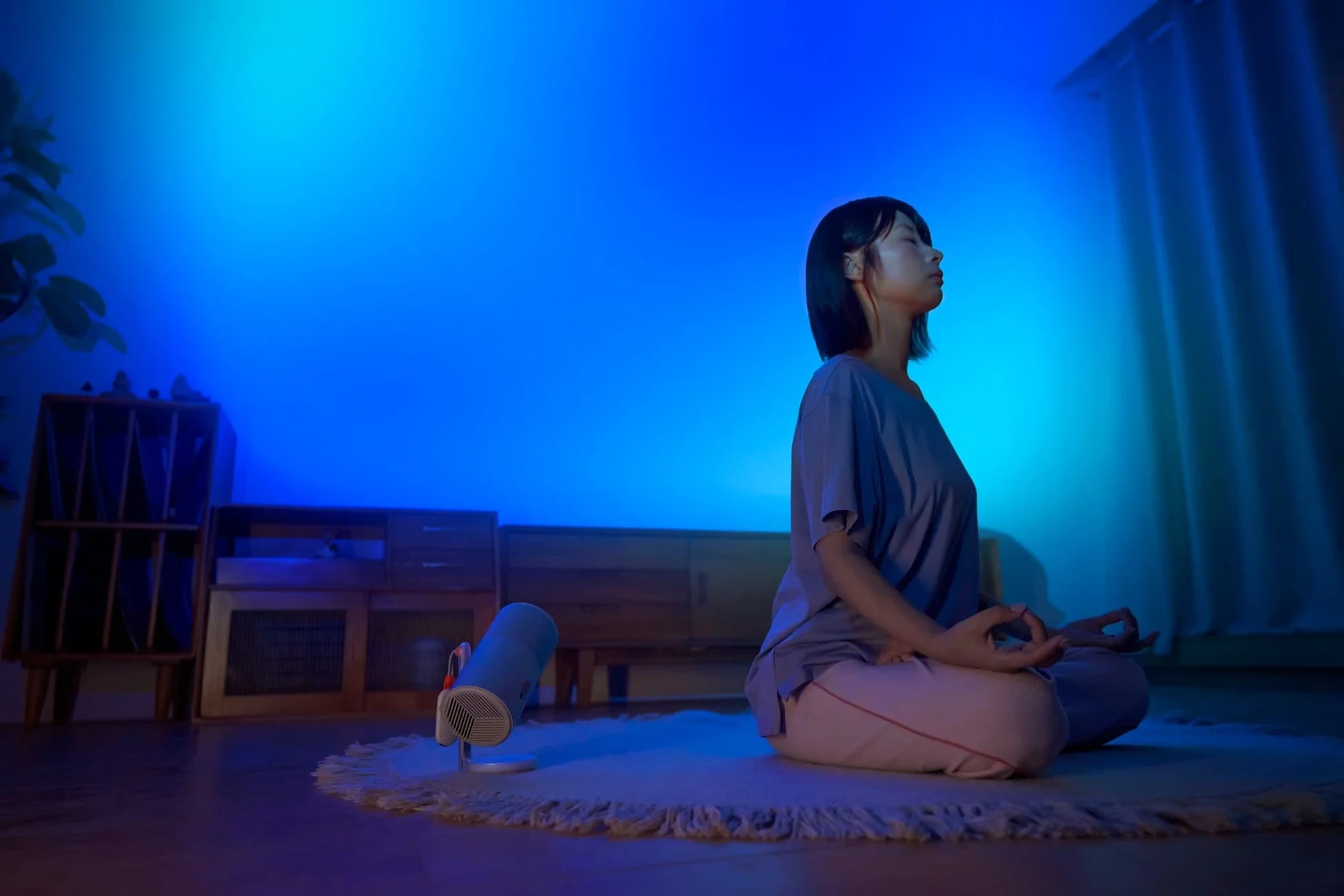 青い光の中で瞑想する女性