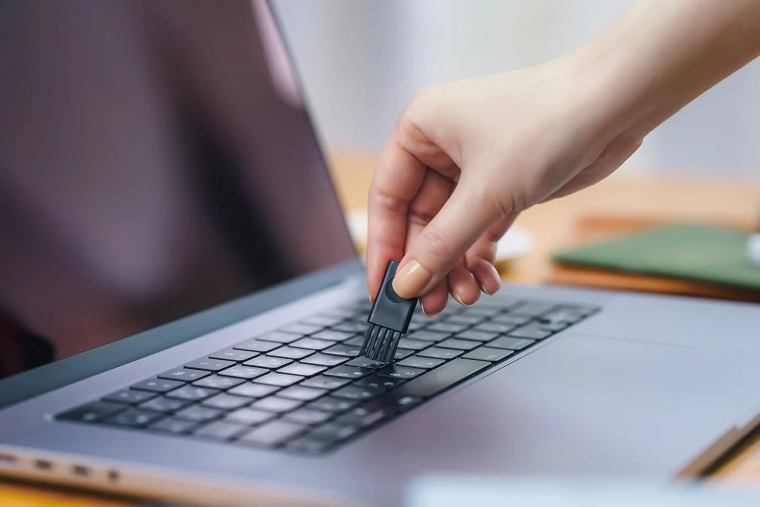 レコルト コードレス スポットクリーナーの隙間ブラシでノートパソコンのキーボードを掃除する様子