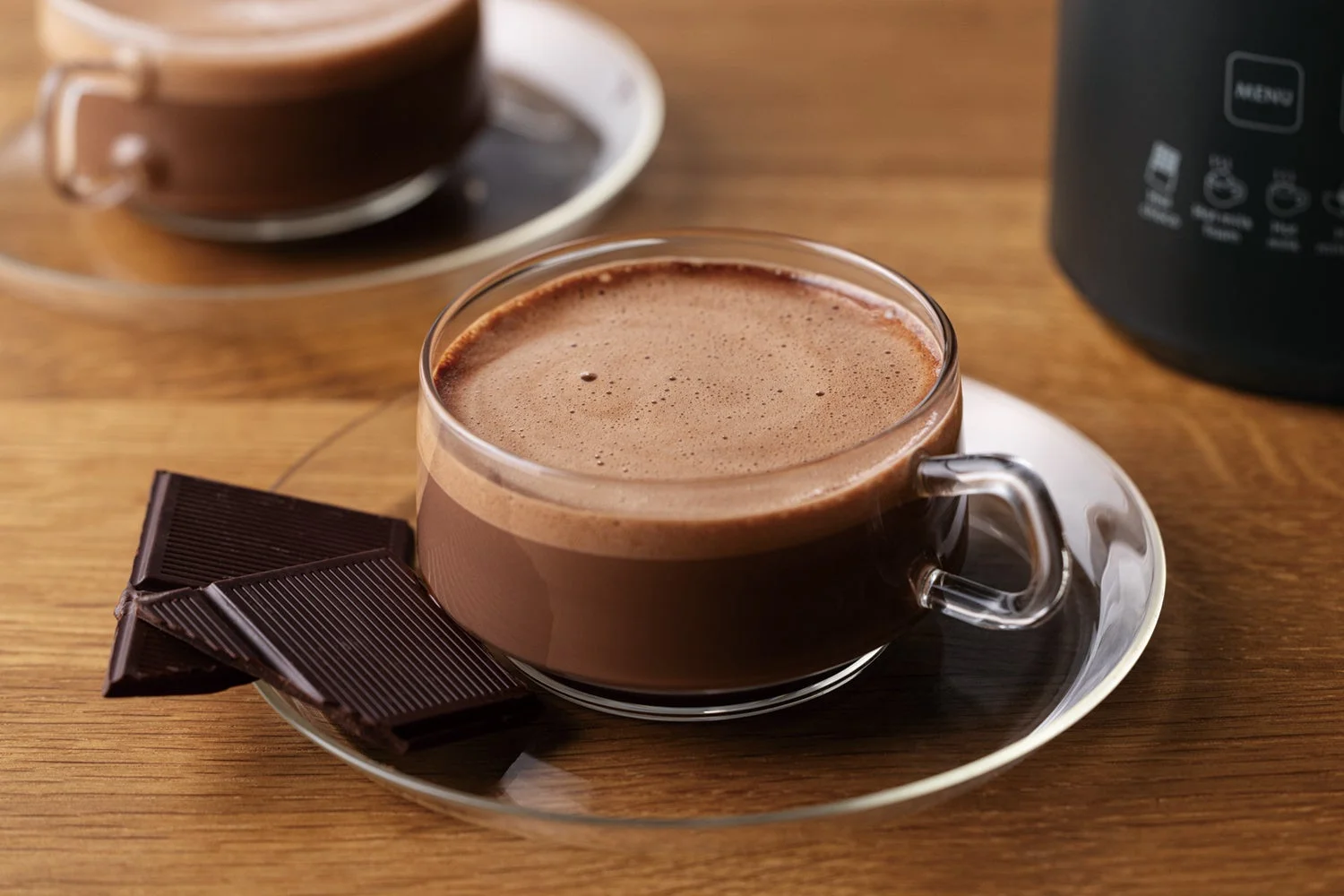 木目テーブルに置かれたホットチョコレート