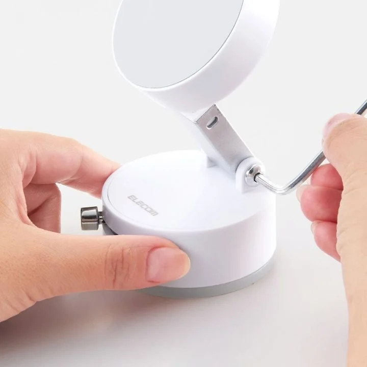 白い円形のデバイスを六角レンチで調整している様子