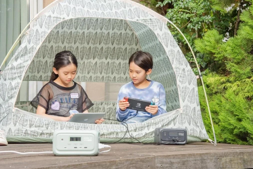テントでデバイスを充電する女の子たち