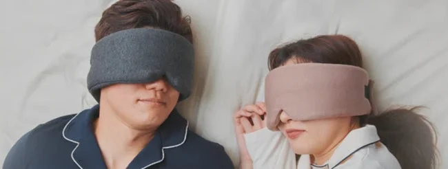 ベッドで横たわるカップルが、それぞれアイマスクを着用して安らかに眠っている様子です。