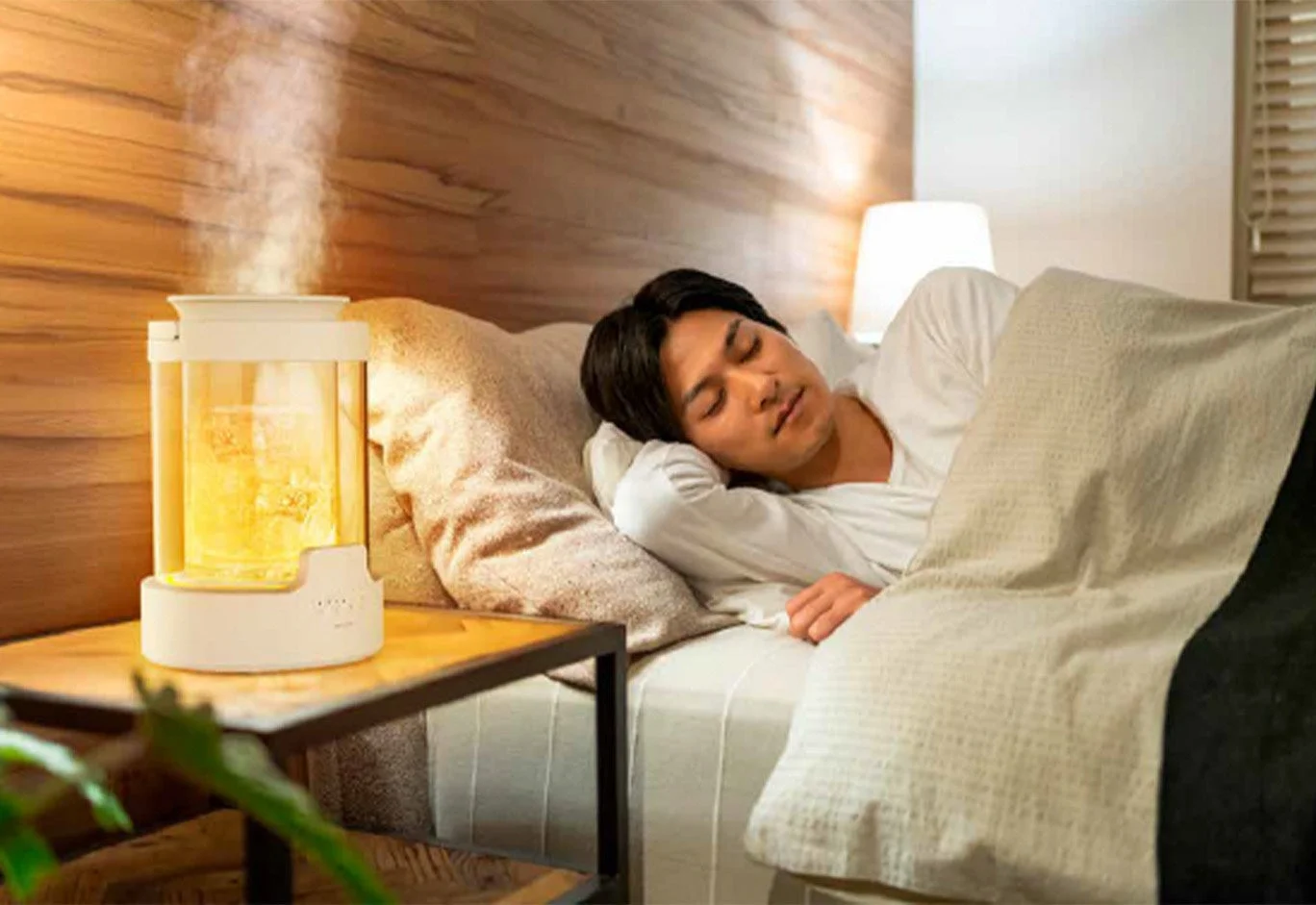 ベッドで眠る男性と加湿器