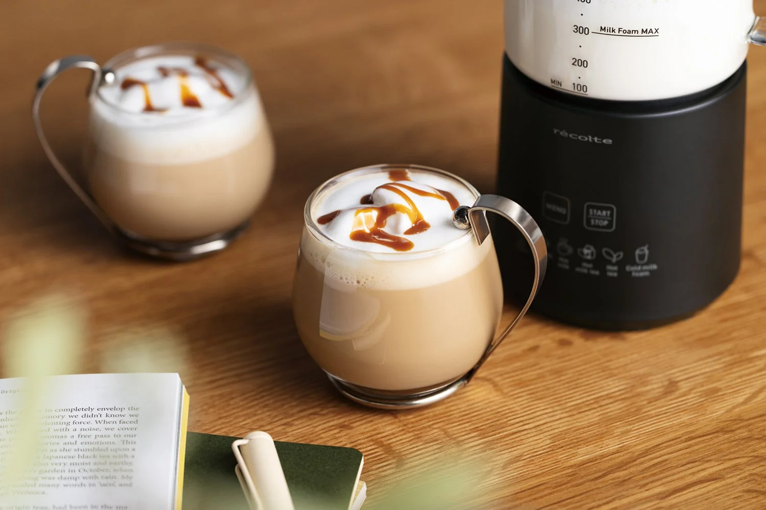 ラテとミルクフォーマー、本が置かれたテーブル