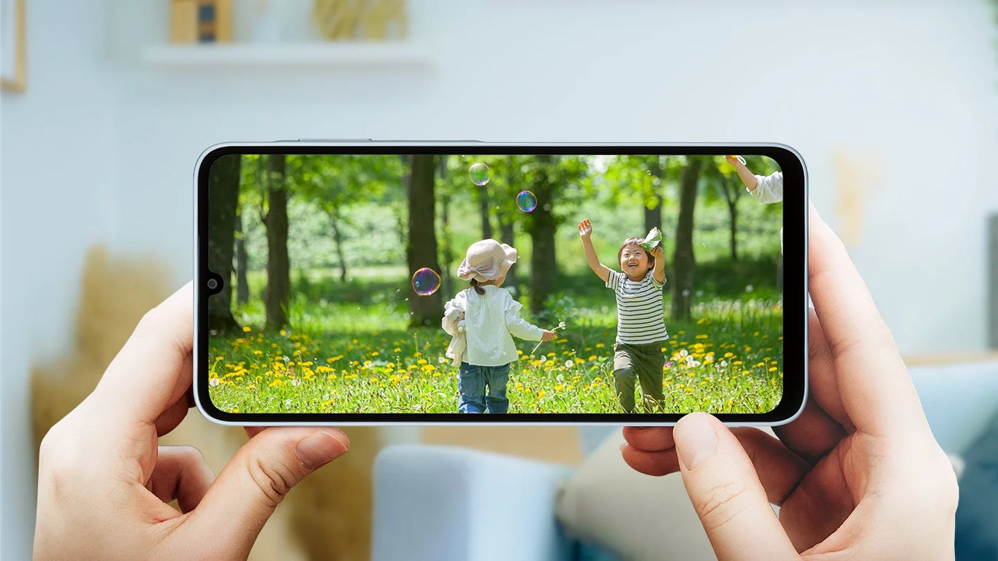 子供がシャボン玉で遊ぶ映像が映るスマホ