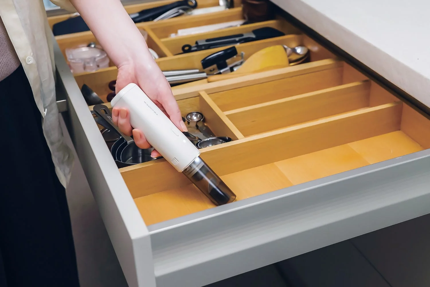 レコルト コードレス スポットクリーナーでキッチンの引き出しを掃除する様子