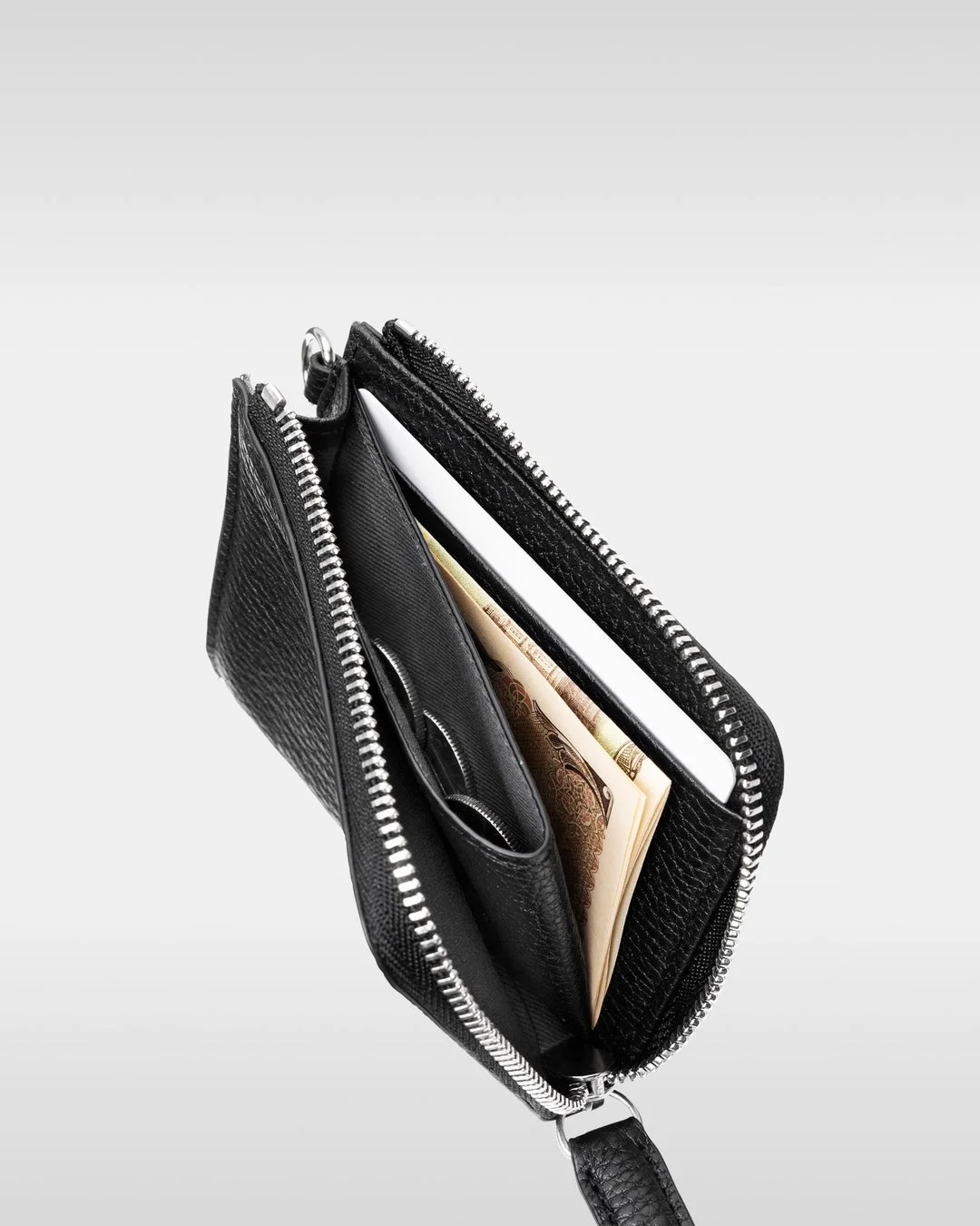 黒い革製のファスナー付き財布と日本の紙幣