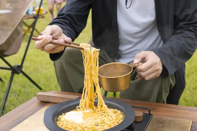 屋外でラーメンを食べる様子を捉えた画像です