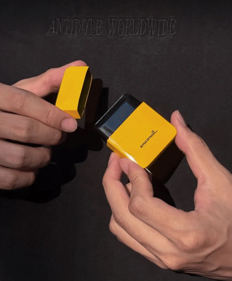 両手で黄色の小さな箱型オブジェクトが開けられている様子