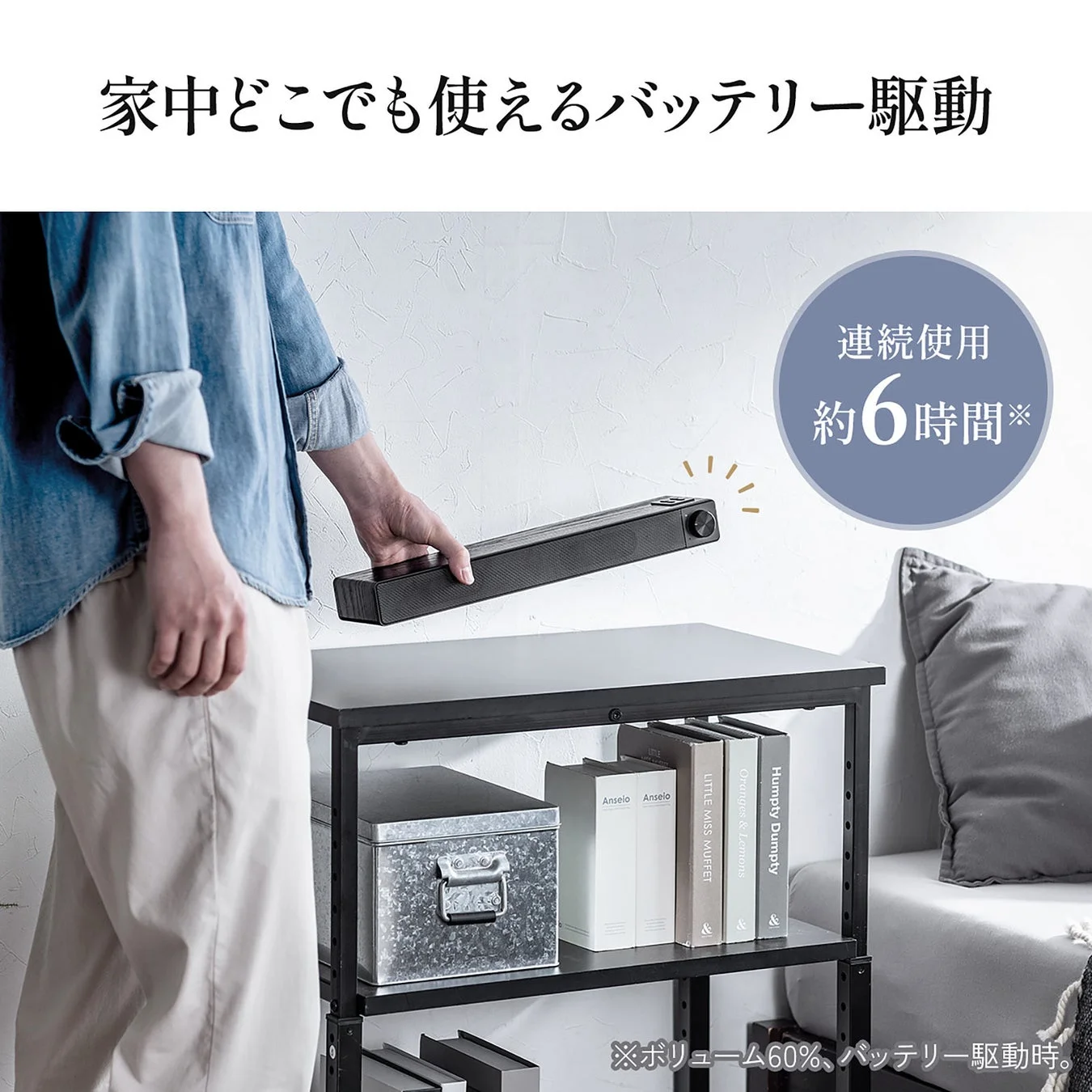 家中どこでも使えるバッテリー駆動のサウンドバーを持つ人物の画像