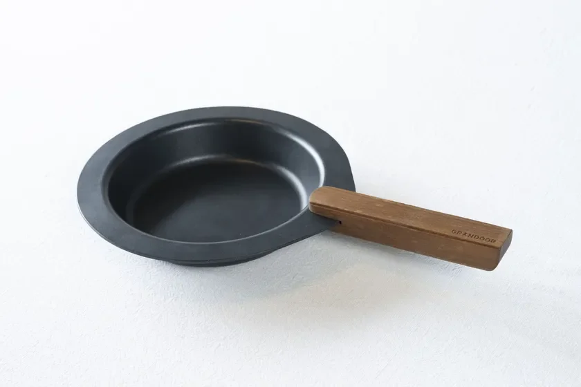 黒いミニフライパンまたはスキレットの画像です。木製のハンドルが付いており、ハンドル部分には「GRANDOOR」の文字が見えます