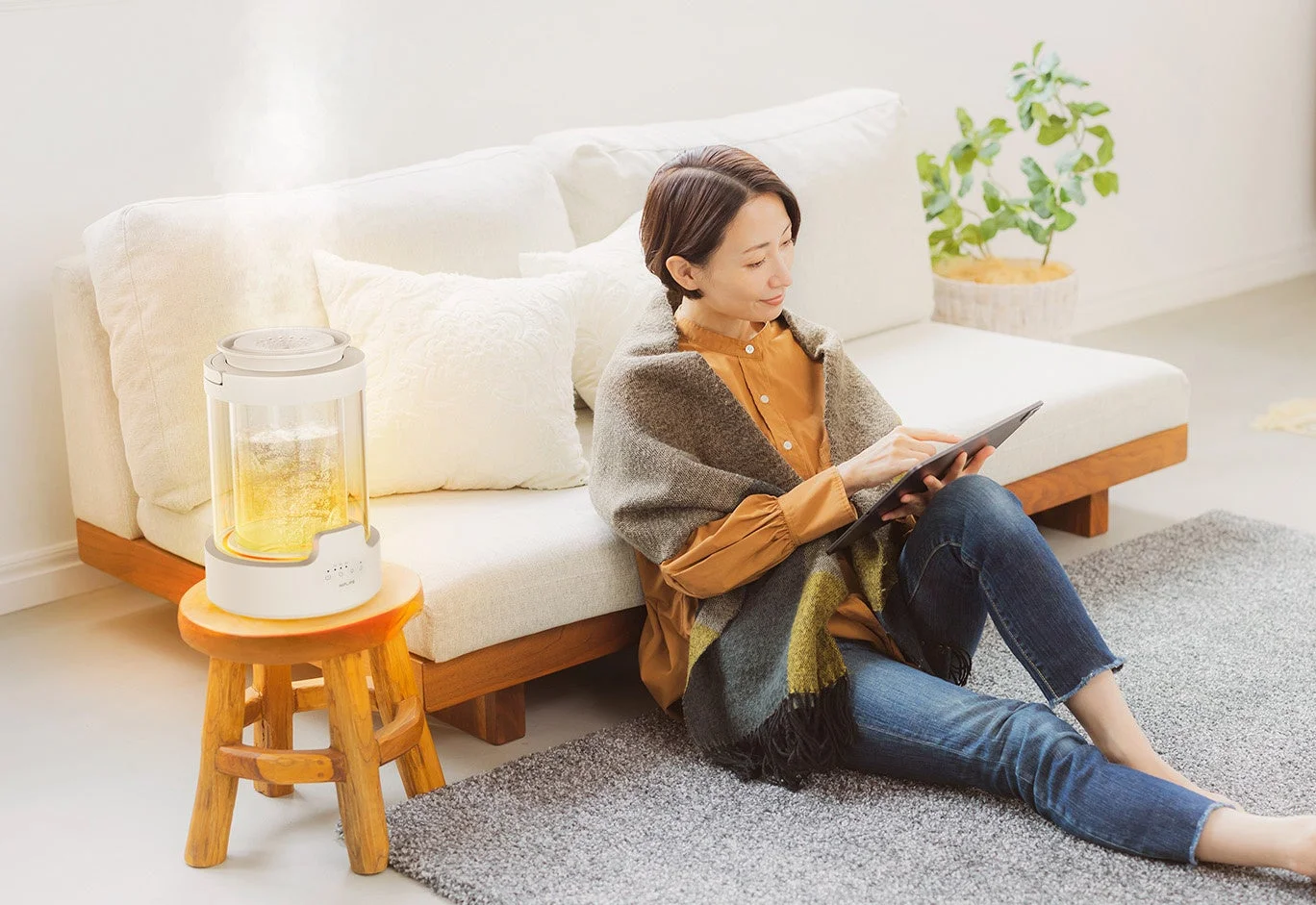 リビングでリラックスする女性と加湿器