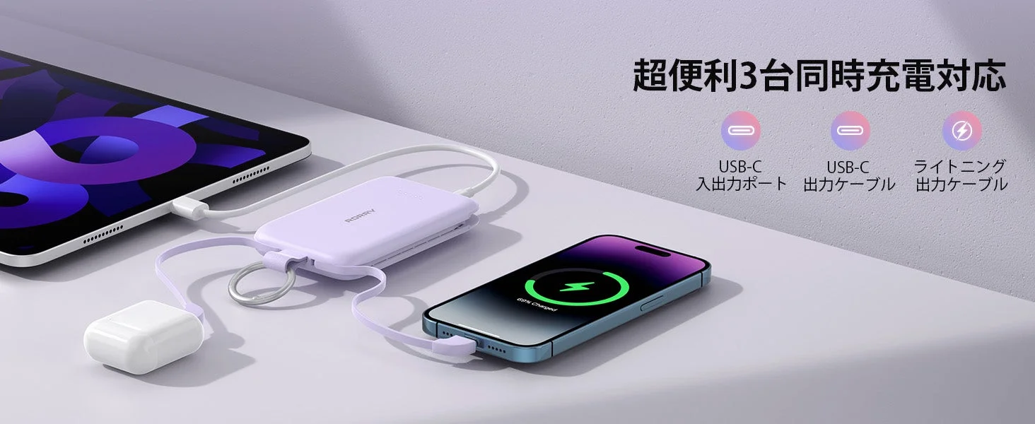 紫色のモバイルバッテリーが、タブレット、スマートフォン、ワイヤレスイヤホンを同時に充電している様子