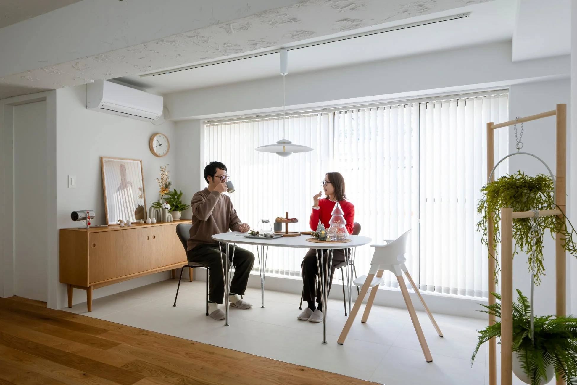 明るくモダンなリビングダイニングでくつろぐカップル