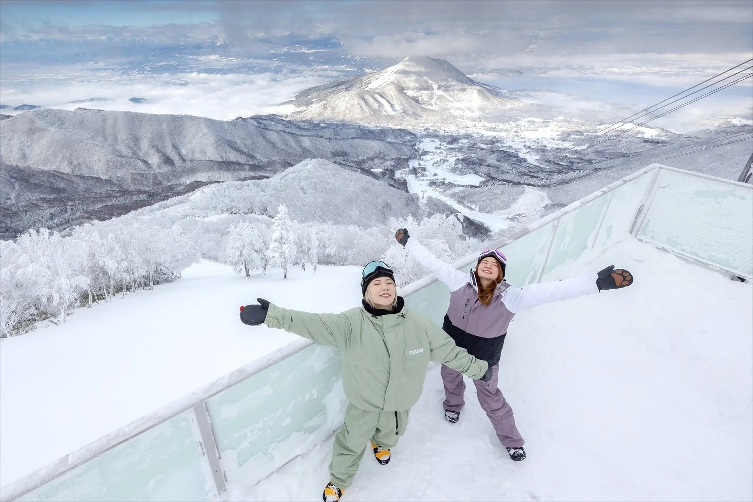 雪山でポーズをとる二人