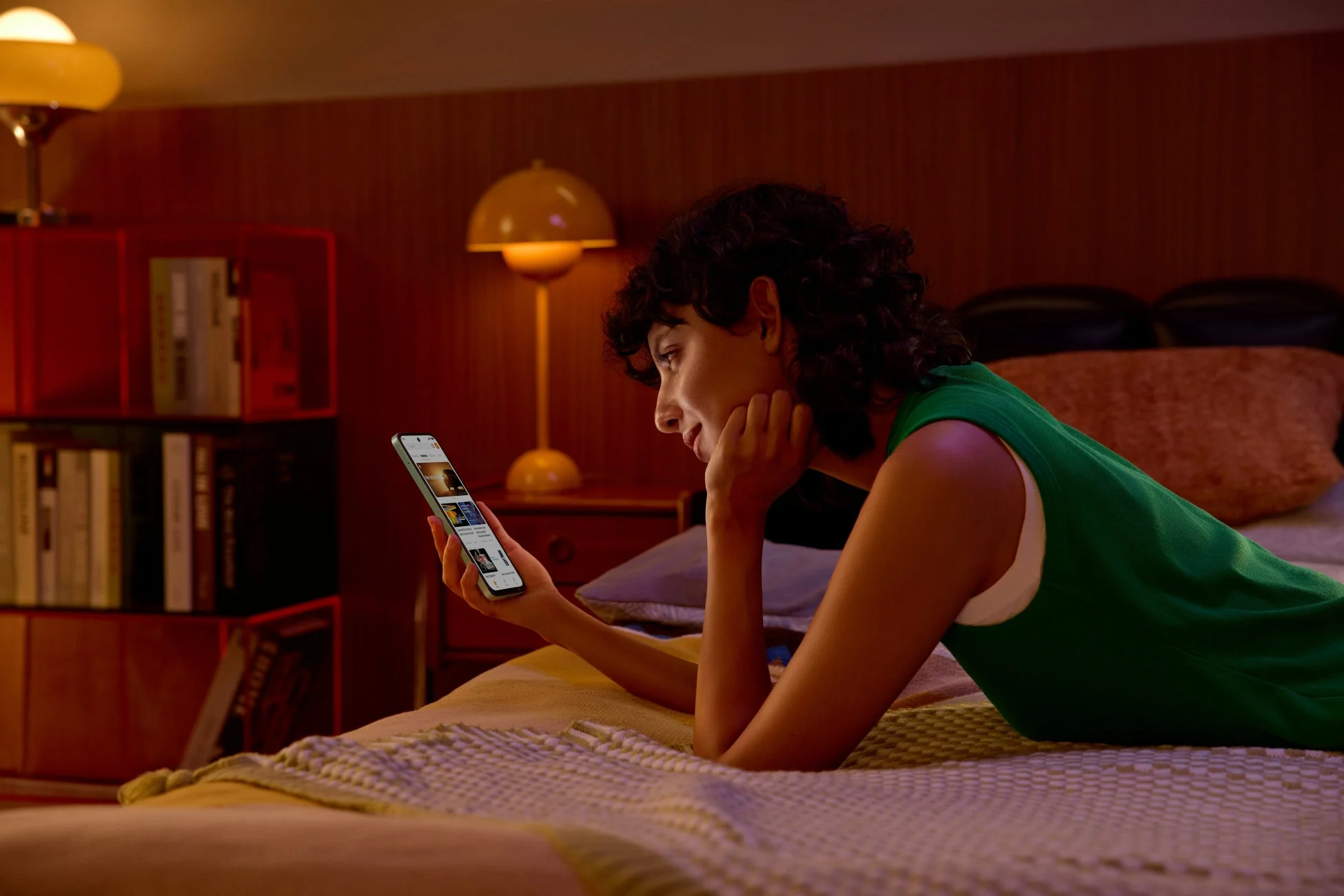 ベッドでスマートフォンを操作する女性