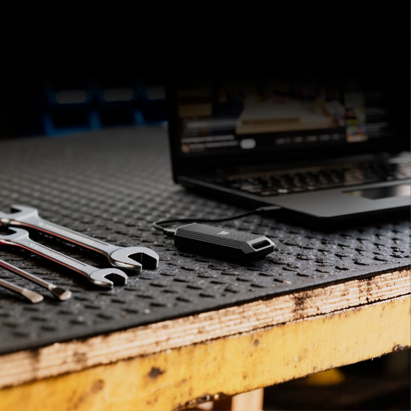 レンチやラップトップとともに置かれた外付けSSD