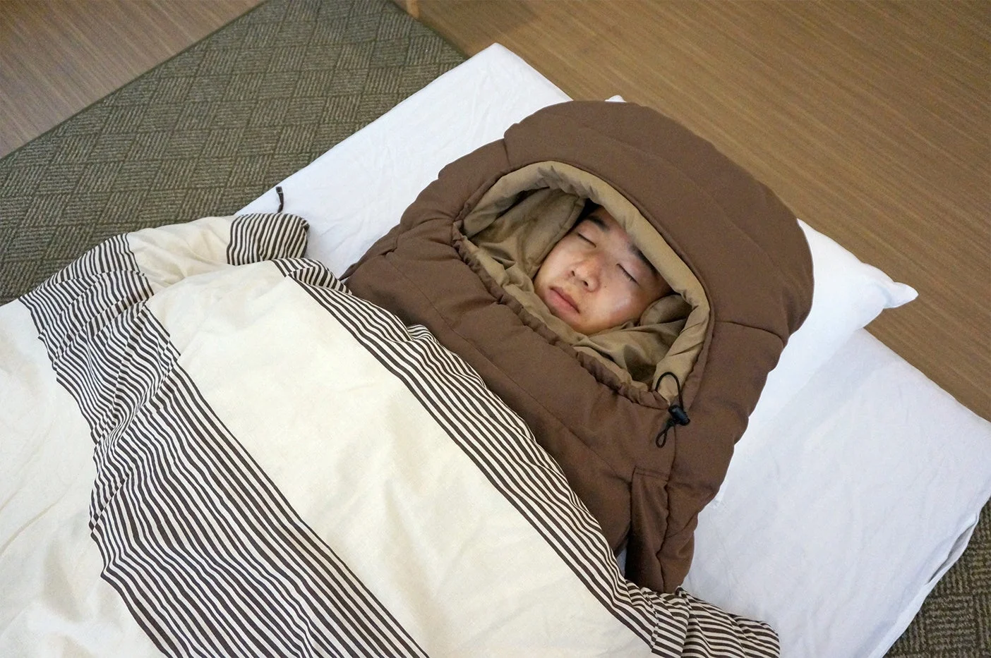 暖かそうな寝袋のようなものに包まれ、気持ちよさそうに眠る人物の姿。快適な寝具で安らかな休息を取っている様子がうかがえます。