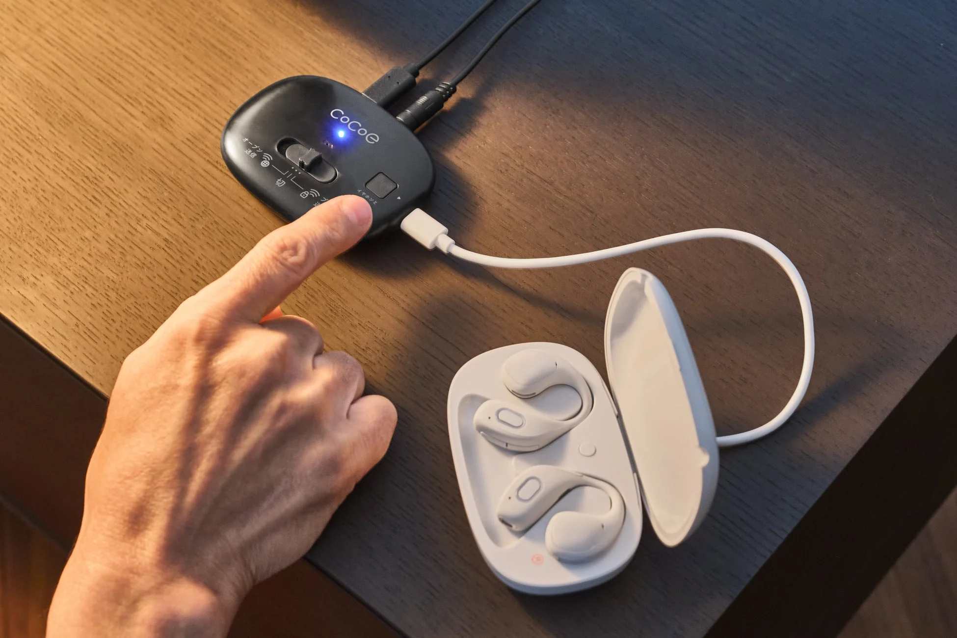 Coeと書かれた黒い音響機器を指で操作している様子