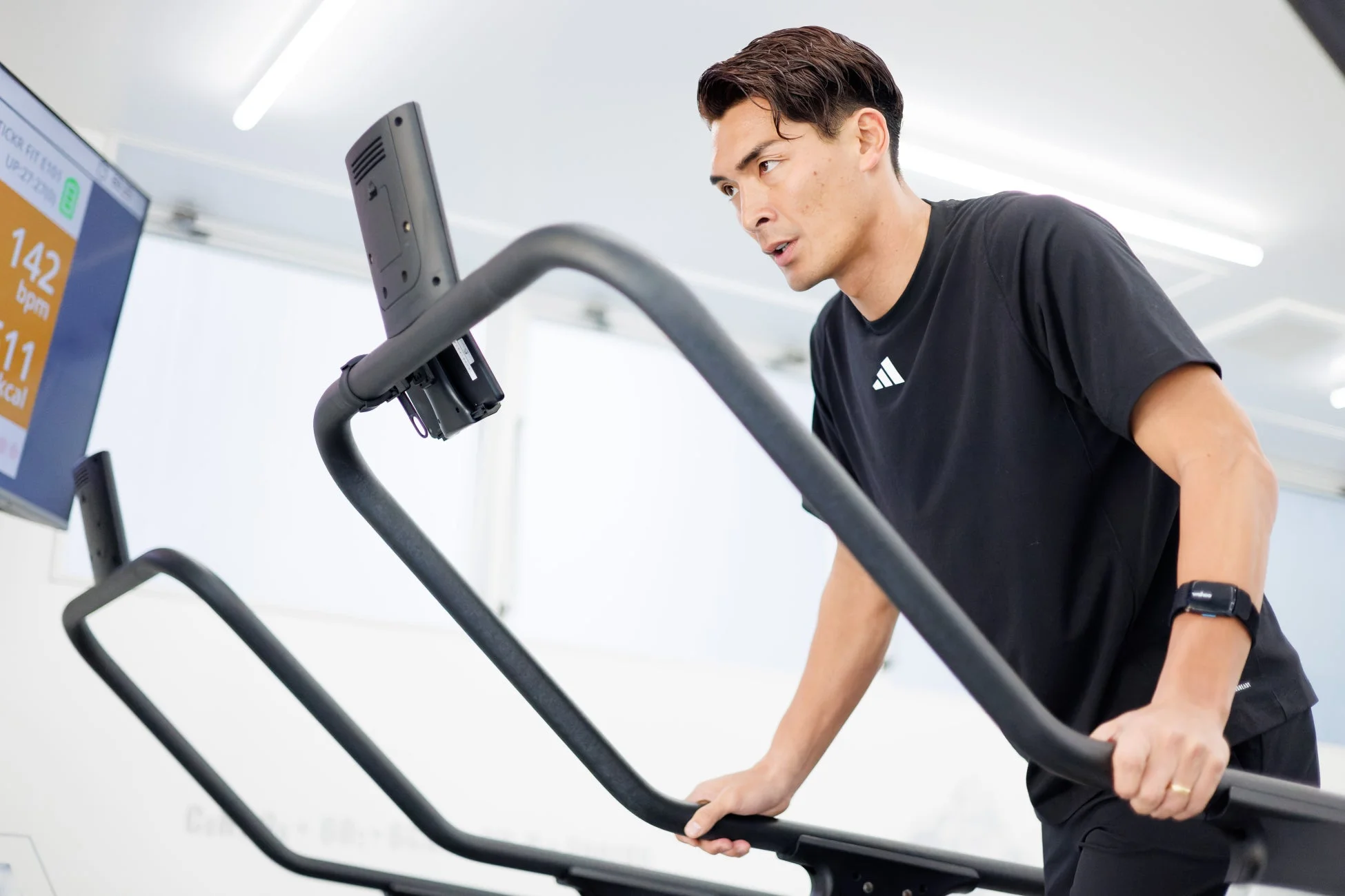 男性がジムでトレーニングマシンを使って運動している様子