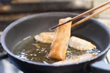 フライパンで春巻きを揚げ焼きしている様子