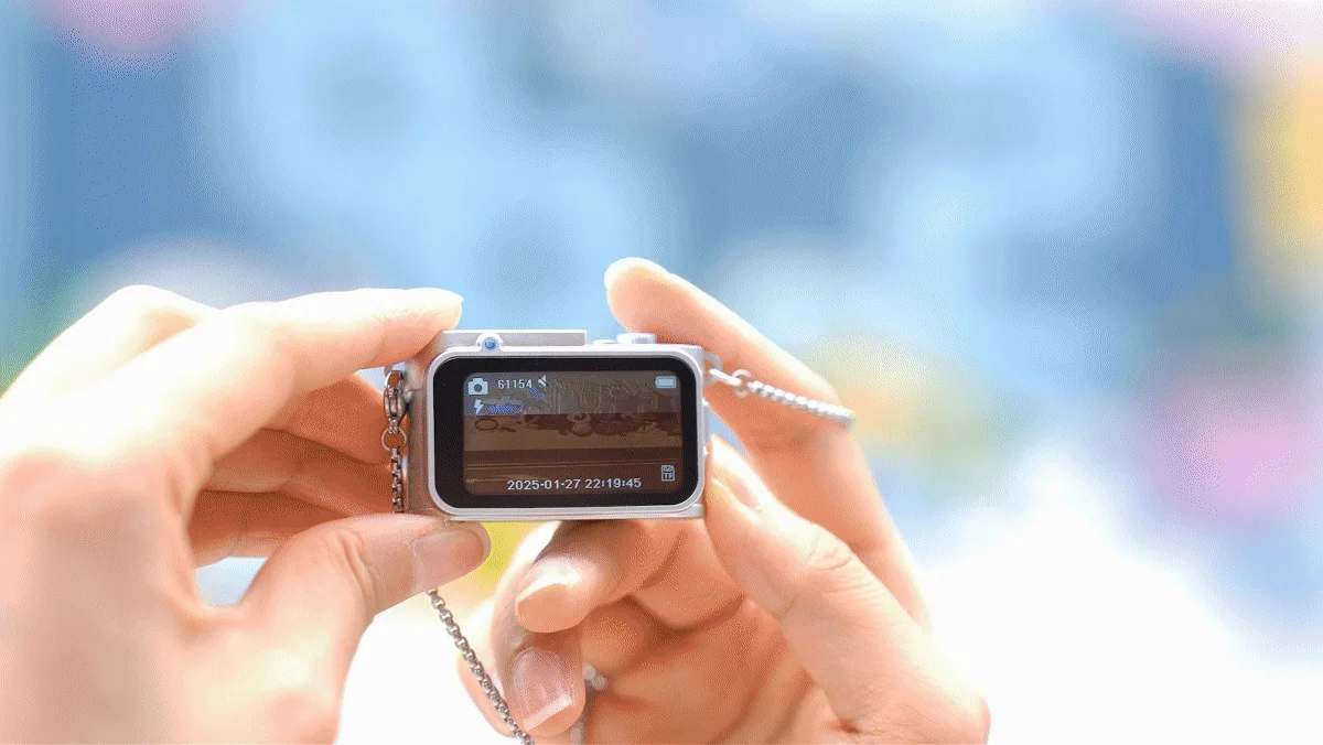 女性が小型カメラを操作し、カラフルな背景を撮影している画像