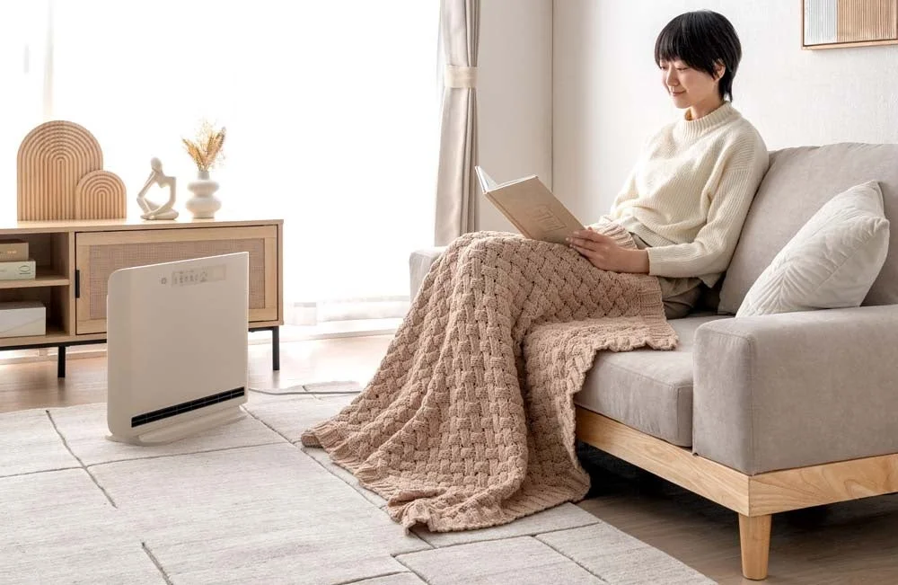 ソファでくつろぐ女性とセラミックヒーター