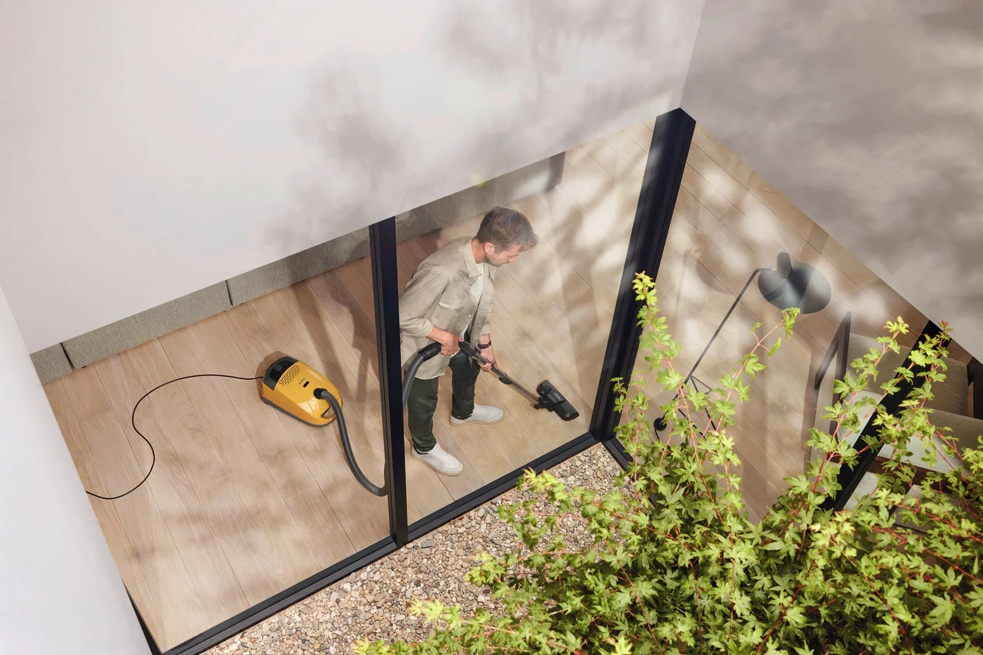 男性が黄色い掃除機で掃除する様子