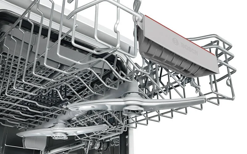食洗機の内部を写した写真で、食器をセットするメタリックなラックや、水を噴射するためのスプレーアームが詳細に映し出されています