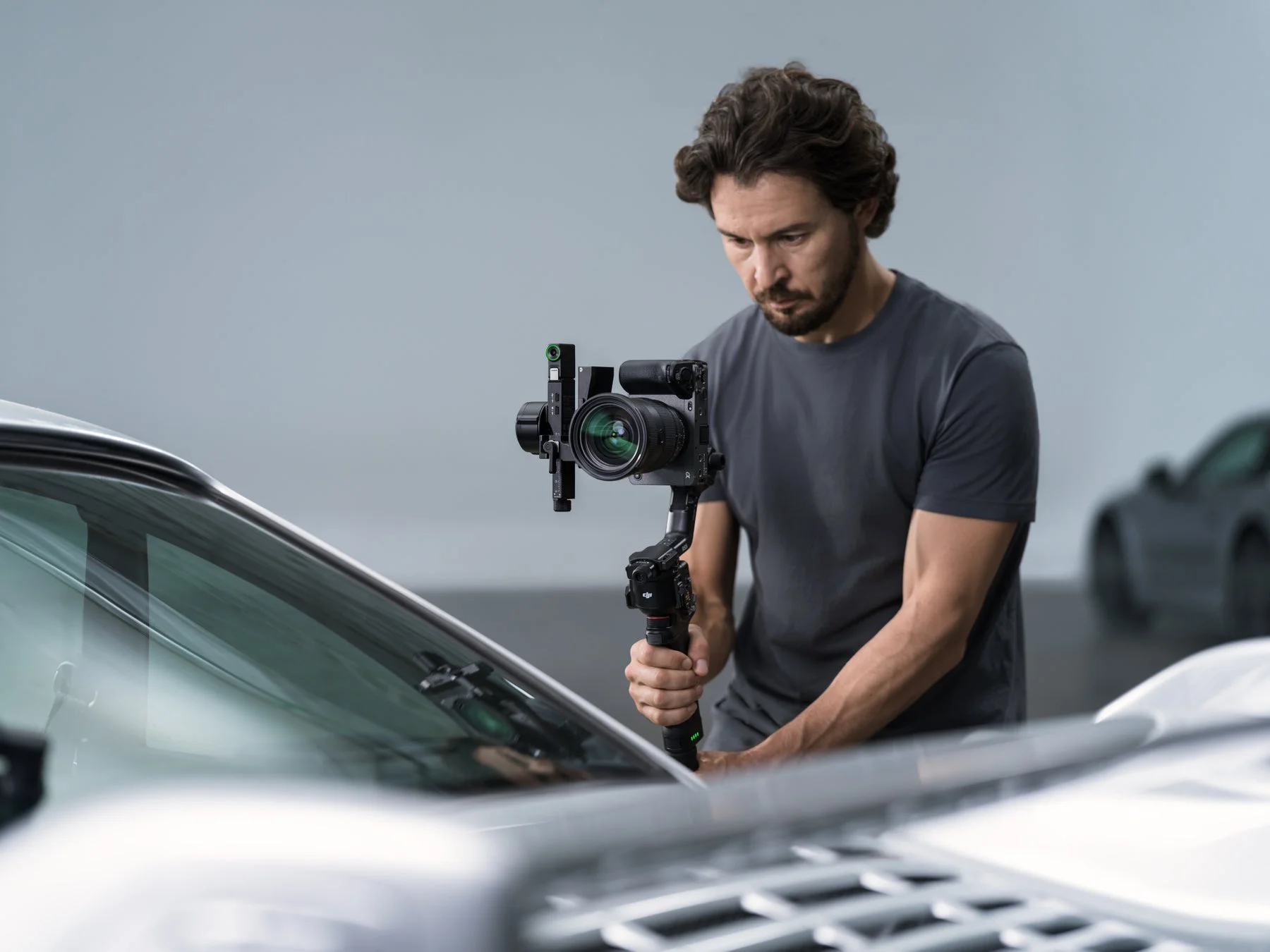 スタジオで車を撮影する男性とジンバル