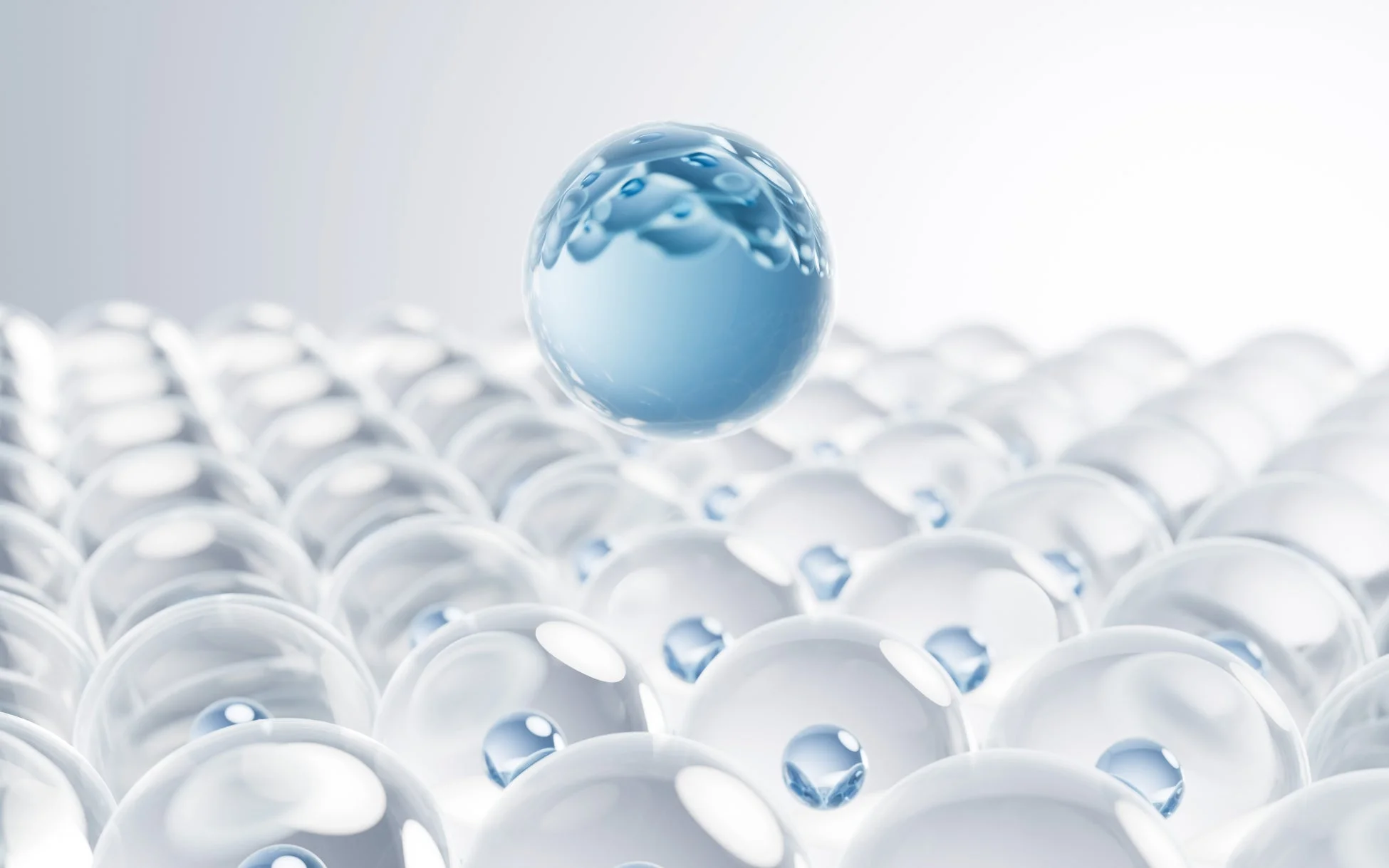 多数の透明な球体の上に青い液体の球体が浮かんでいる抽象的なイメージ