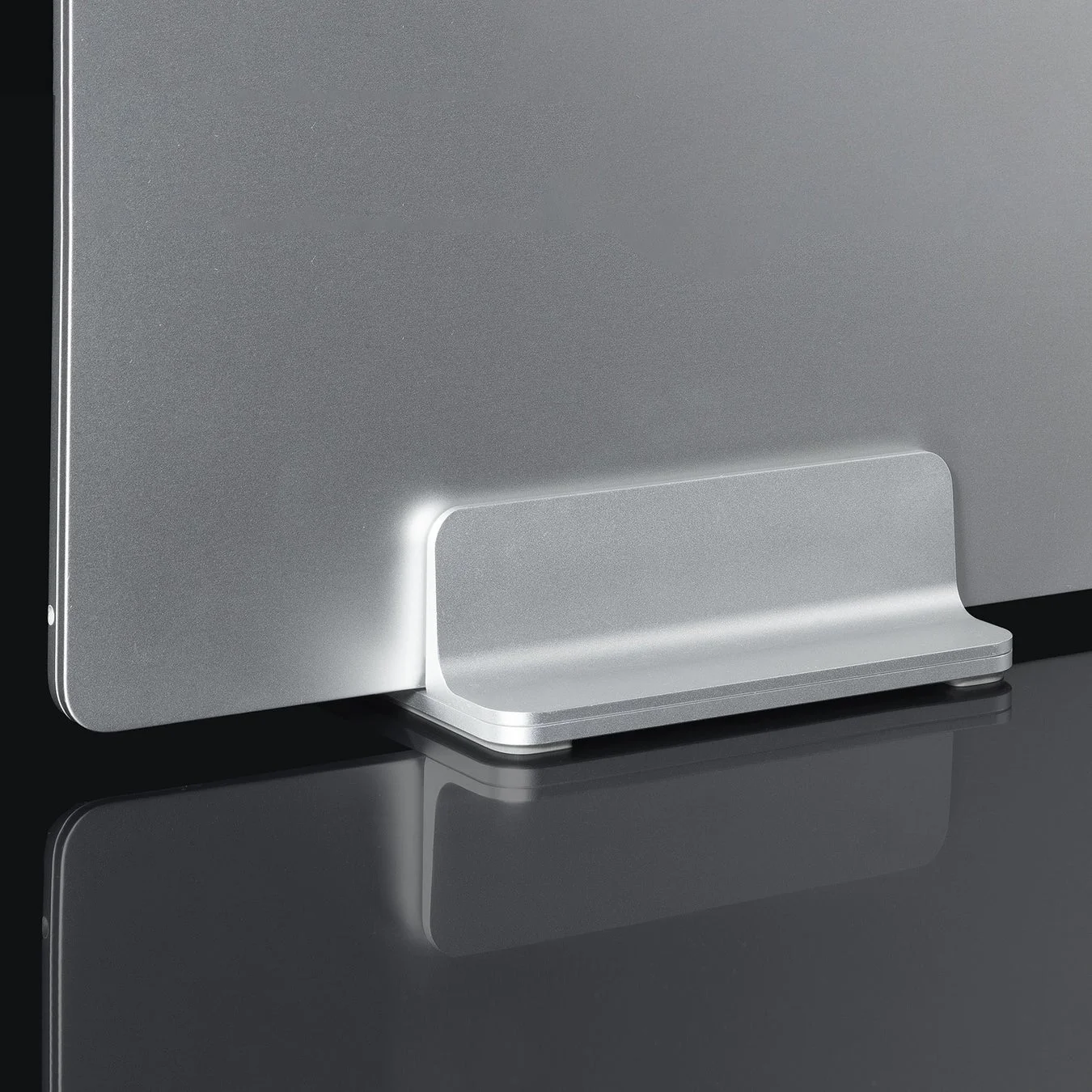 シルバーの電子機器が、同じくシルバーのミニマルなスタンドに立てかけられています