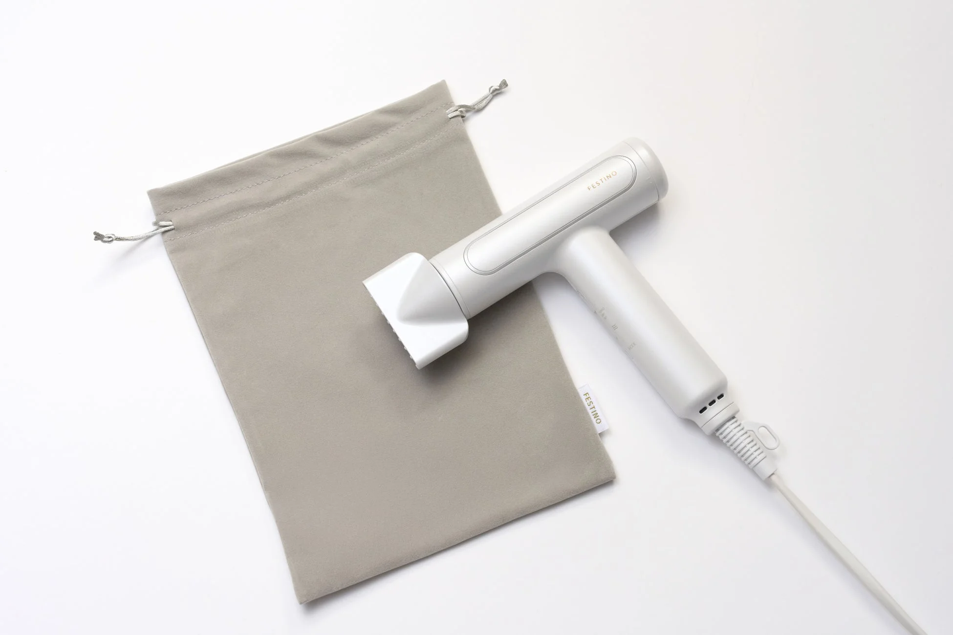 白いヘアドライヤーとグレーの巾着袋が白い背景に置かれている製品写真