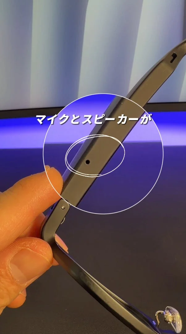 スマートグラスのつるの部分をクローズアップし、マイクとスピーカーの場所を白い円とテキストで示しています。