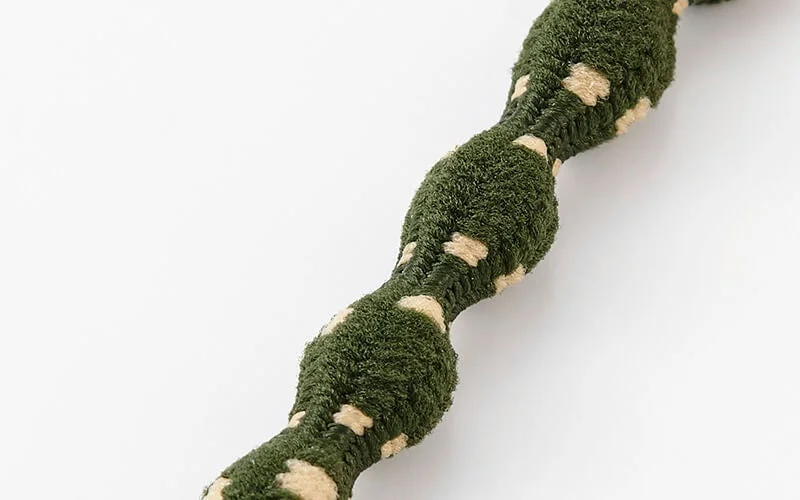 緑色でベージュの斑点模様が入ったでこぼことした質感の太いコードまたはロープ