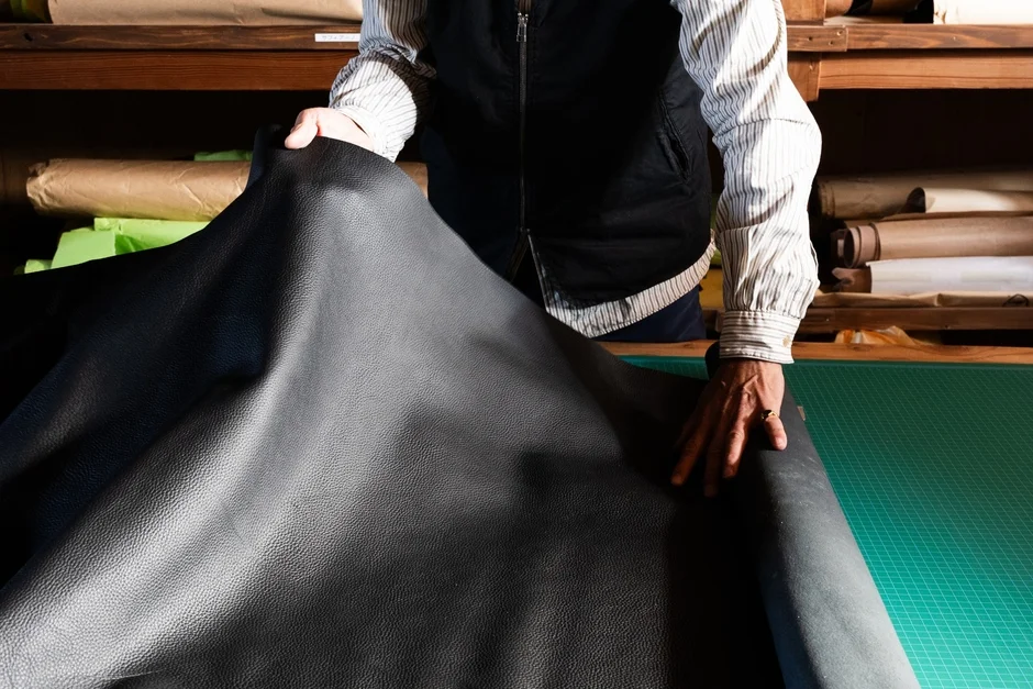 作業場で広げられた黒い革のシート