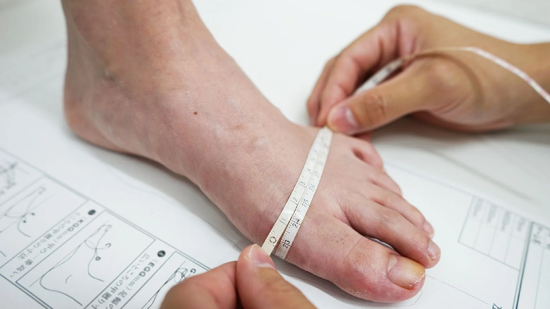 メジャーを使って人の足囲を測っている様子