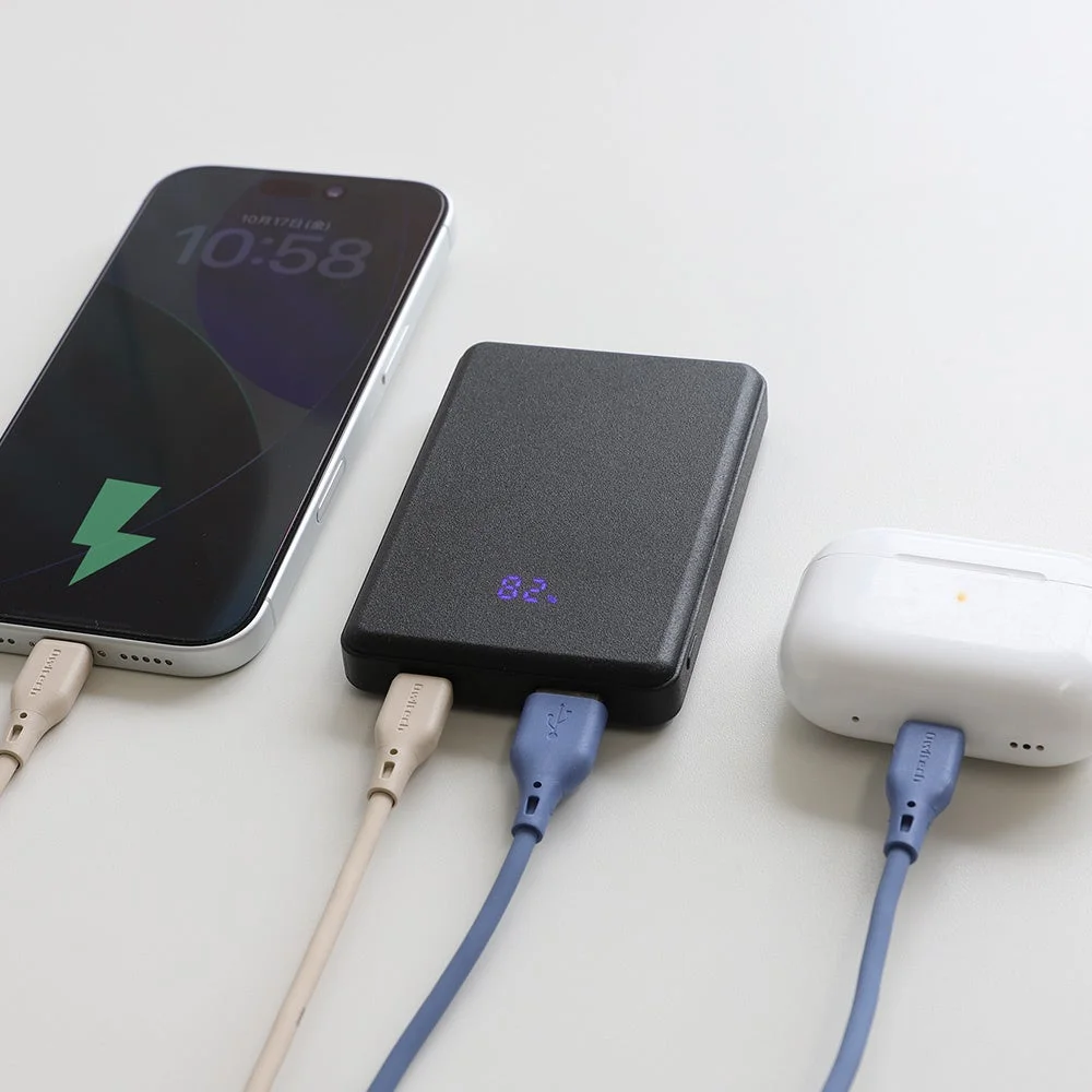 スマートフォンとワイヤレスイヤホンを同時に充電中のモバイルバッテリー