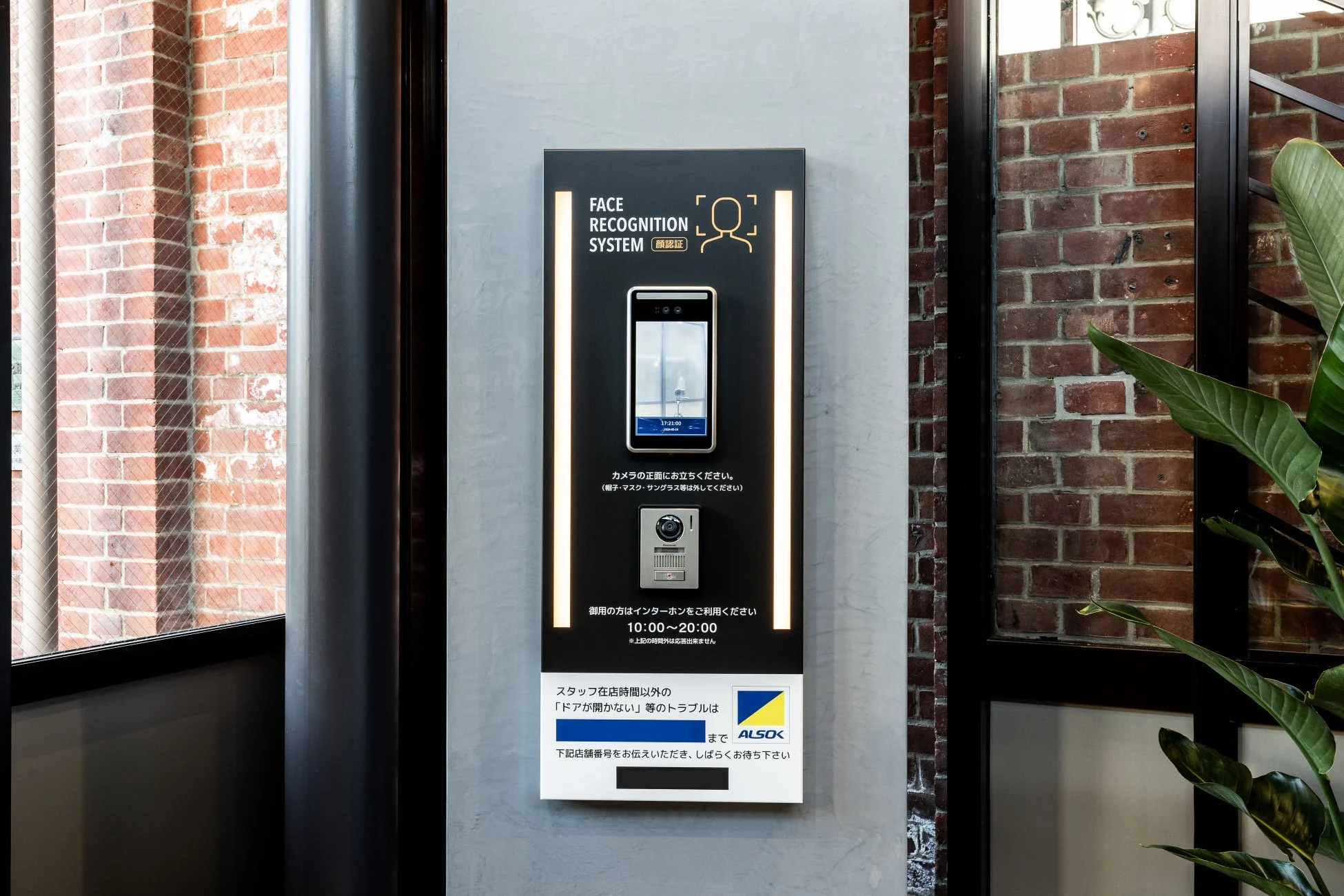 建物のエントランスに設置された顔認証システムとインターホンの案内板