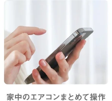 スマートフォンでエアコンを操作する手