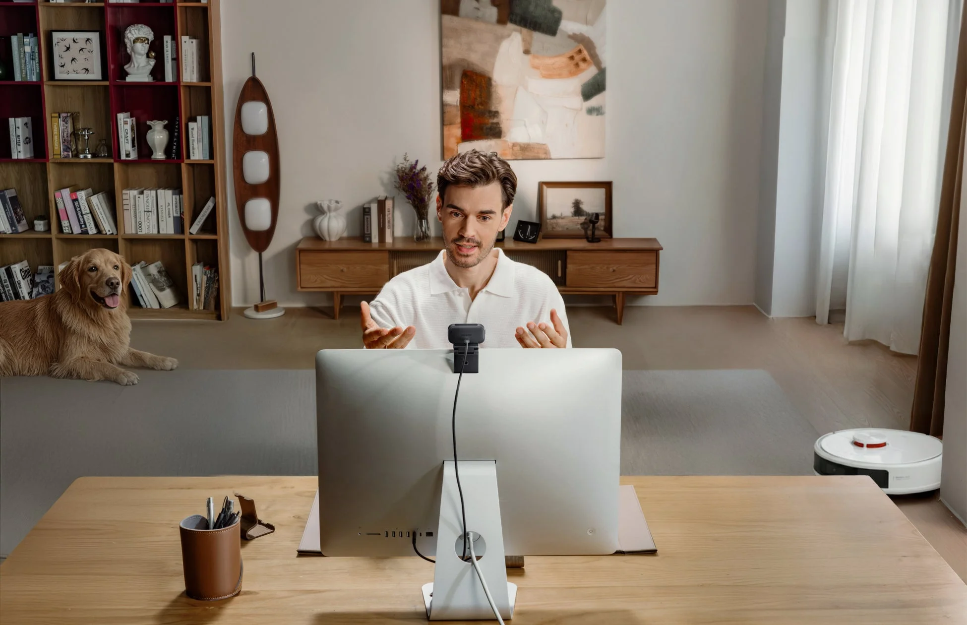 ウェブカメラを使ってビデオ会議をする男性と犬