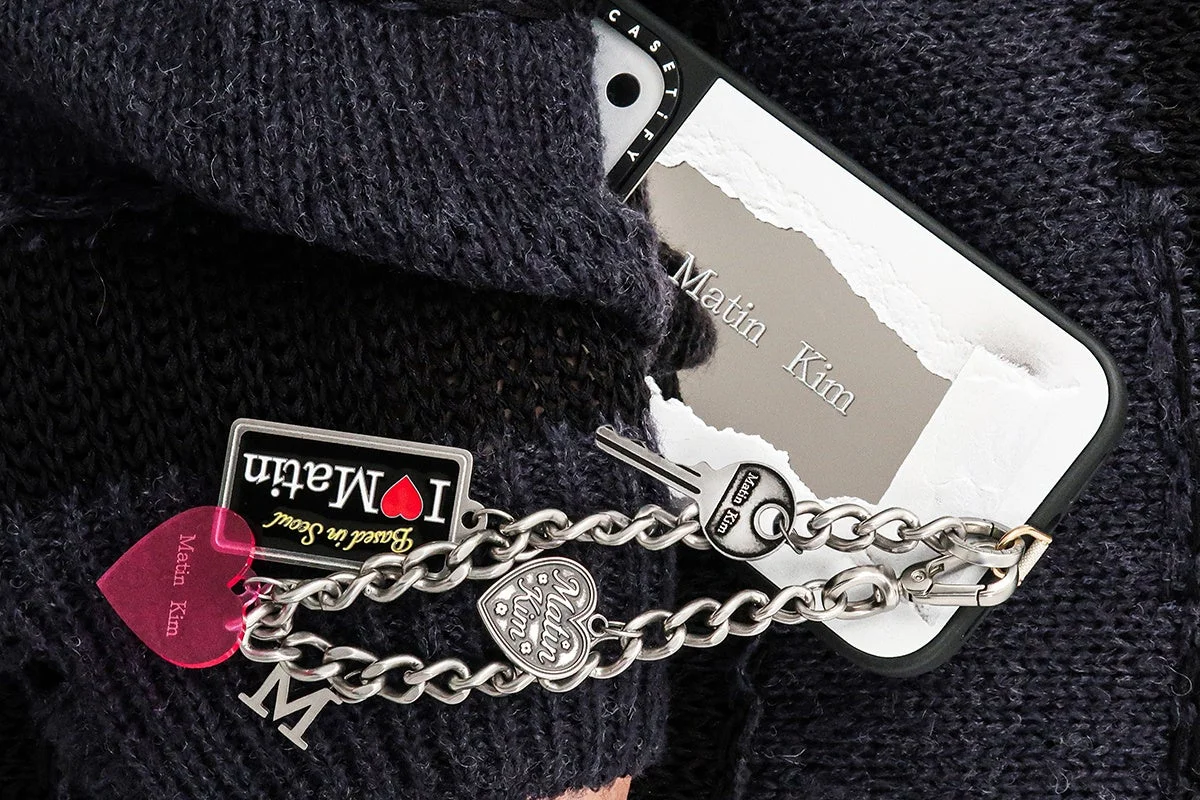 Matin KimとCASETiFYのロゴ入りスマホケースと、複数のチャームが付いたキーホルダー