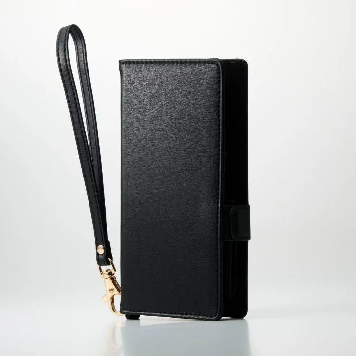 白い背景に置かれた、リストストラップ付きの黒い手帳型スマホケース
