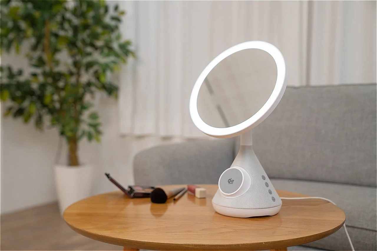 LEDライト付きの化粧鏡が木製テーブルに置かれ、スピーカー機能も搭載。モダンなリビング空間