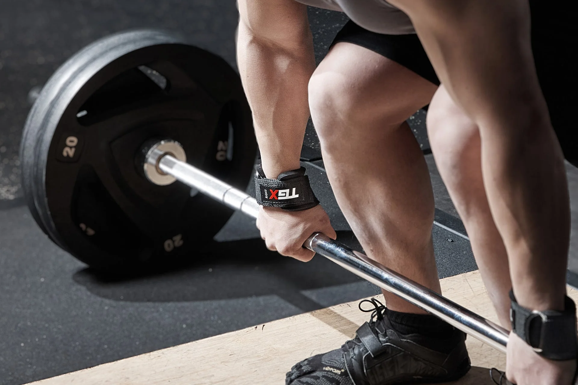 ジムでバーベルを持ち上げようとしている人物のクローズアップ